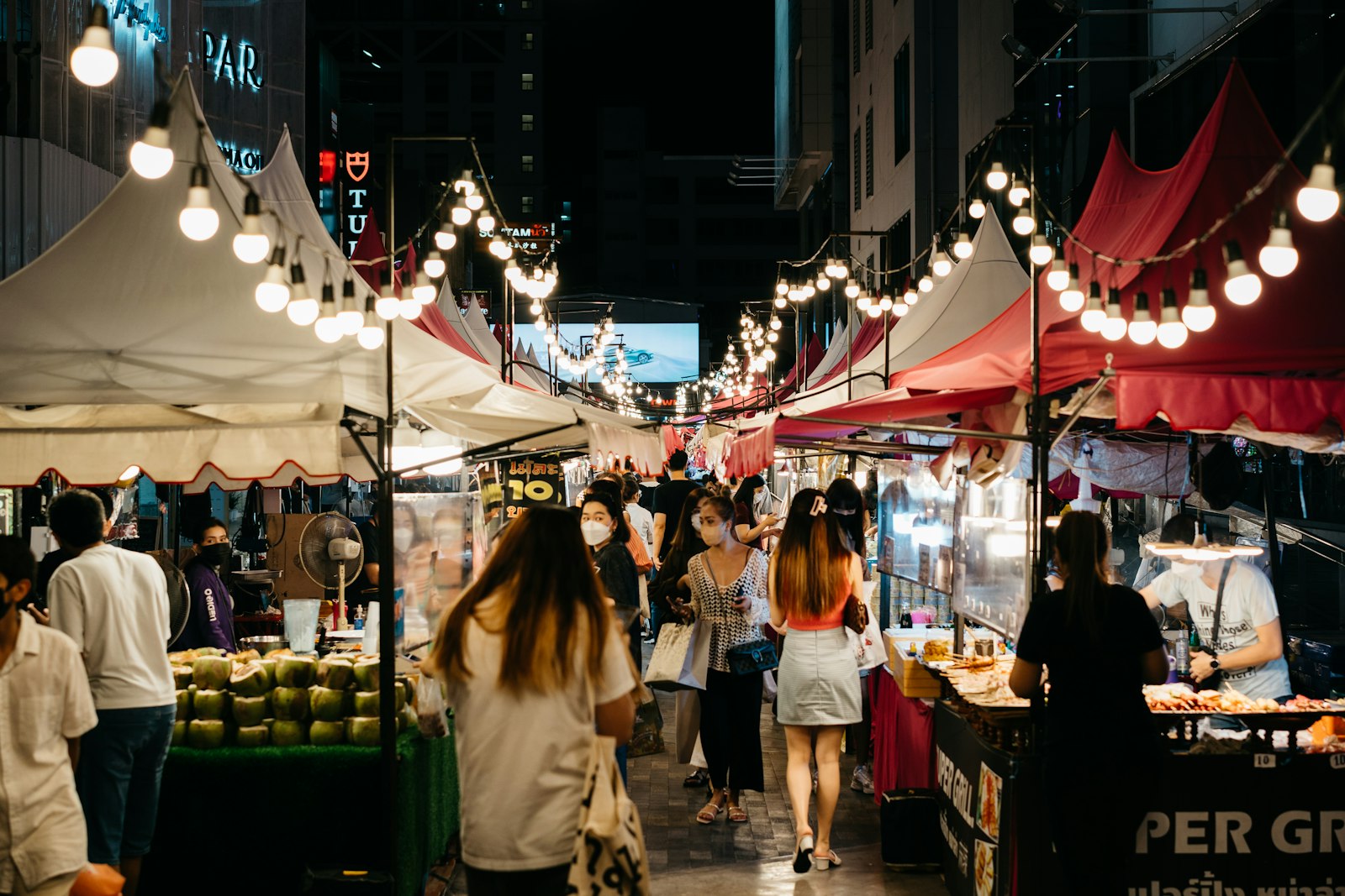 Night market with vendor tents and string lights